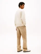 Buzo de algodón color crema, de corte holgado, con cuello redondo, puños y bajo acanalados. Presenta un parche con el logo de Tommy Jeans con estampado de cachemir en el frente y otro parche con el logo en la manga.