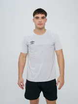Remera deportiva Umbro modelo Axis, de manga corta, color gris claro con textura perforada transpirable y logo negro de la marca en el pecho.