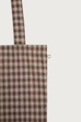 Bolso tipo shopper de la colección Benito Antonio x Zara, confeccionado en tejido con estampado a cuadros en tonos marrones y blancos. Cuenta con compartimento principal sin cierre, doble asa de mano y un pequeño bordado distintivo en la parte inferior.