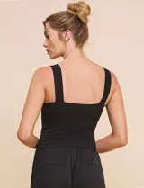 Top crop negro de corte ajustado y estructurado, con escote corazón, tirantes anchos y textura acanalada fina con costuras estilo corsé.