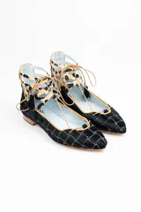 Botines bajos negros con diseño tejido y cordones con borlas. Presentan detalles de animal print en el tobillo y ribete ocre.