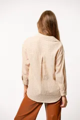 Camisa a rayas verticales grises y blancas, de corte recto y mangas largas.