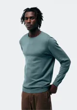 Buzo de tejido liso, color verde azulado, con cuello redondo y manga larga.