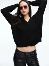 Cardigan de punto con hilo brillante, cuello en V y cierre frontal con botones. Presenta mangas largas con puños acanalados y un diseño de calce holgado.