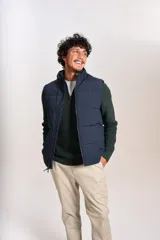 Chaleco tipo puffer color azul marino, con cierre frontal completo, cuello alto y logo bordado en el pecho.