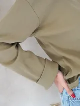 Remera de manga larga color verde oliva, con cuello redondo y tejido acanalado.