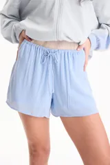 Short fluido de viscosa con diseño a rayas verticales celestes y blancas, cintura elástica fruncida y cordón ajustable.