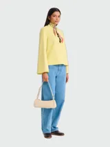 Cartera de hombro pequeña Longchamp modelo Looong, de diseño minimalista y estructura rígida en color beige claro. Cuenta con cierre superior y correa de hombro fija.