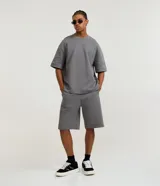 Bermuda masculina de algodón y poliéster, color gris oscuro, con cintura elástica y cordón ajustable. Presenta bolsillos funcionales.