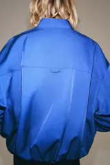 Chaqueta bomber de Zara Woman Collection color azul, con escote en pico, manga larga abullonada con puños elásticos, bolsillos delanteros y cierre frontal cruzado.