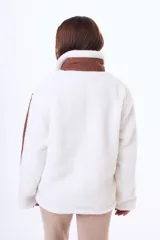 Campera de corderito sintético color blanco, con detalles en color marrón en el cierre, cuello y mangas. Posee cierre frontal y bolsillos laterales.