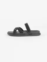 Sandalia plana marca Symphorine, color negro con acabado texturizado tipo charol. Presenta una tira superior ajustable y tiras cruzadas en el empeine.