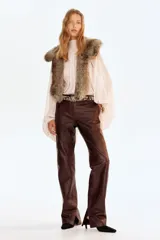 Blusa oversized de tejido liviano con efecto arrugado, cuello elevado drapeado con abertura en V, frunces frontales y tiras largas en la espalda. Presenta mangas globo largas de corte raglán con costura interior abierta y puños elásticos.