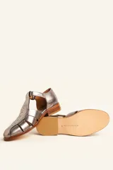 Sandalia cerrada tipo pescador de cuero negro charol, con tira en T y hebilla ajustable en el tobillo. Posee suela y taco bajo de madera.