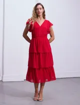 Vestido blanco de gasa con capas, marca Julia Jordan. Escote en V, manga corta con volados, corte en cintura y abertura central en espalda con cierre invisible.