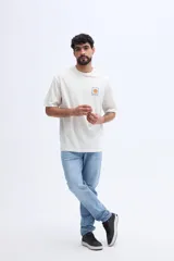 Remera oversize color blanco de algodón, con cuello redondo, mangas cortas y estampa pequeña en el pecho con diseño de sol.