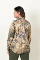 Camisa de satén con estampado paisley en tonos mostaza, azul y marrón. Tiene cuello camisero, mangas largas con puños abotonados y cierre frontal con botones dorados.