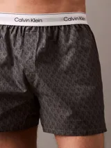 Bóxer suelto de hombre Calvin Klein, confeccionado en popelín de algodón con estampado de logos en gris y cintura elástica blanca con logo.