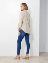 Blusa de gasa color beige, marca Floral & Ivy, con cuello a la base y escote en V. Las mangas son largas y regulables con presilla y botón.