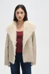 Chaqueta de eco-cuero negro con interior y cuello de piel sintética, diseño holgado, manga larga y cierre frontal con un botón.