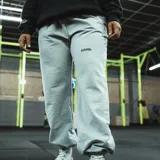Pantalón de jogging gris melange, corte oversize, con cintura elástica ajustable con cordón y puños ajustados. Estampado en la pierna izquierda con la frase "Just Begin".