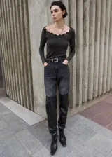 Remera de manga larga gris oscuro con cuello en V adornado con detalles de puntilla negra.