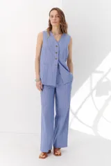 Pantalón de vestir marrón claro con finas rayas verticales blancas, de corte recto y relajado.