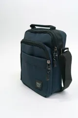 Morral de diseño compacto en color azul marino, con múltiples compartimentos con cierre, manija superior y correa ajustable para llevar al hombro. Incluye etiqueta con logo de la marca en la parte frontal.