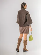 Chaqueta tipo capa de lana bouclé en color marrón, con cuello mao y cierre frontal de botones grandes. Presenta mangas tres cuartos con puños ajustados de tejido acanalado.