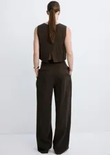 Pantalón de corte recto y tiro medio color marrón oscuro, confeccionado en lyocell, con detalle de pinzas delanteras, trabillas para cinto, bolsillos laterales y bolsillos de ribete en la parte posterior. Cierre frontal con botón y cremallera.