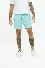 Short de baño liso con cintura elástica y cordón ajustable. Cuenta con dos bolsillos laterales, un bolsillo trasero y logo bordado en el ruedo. Confeccionado en tejido ligero de secado rápido.