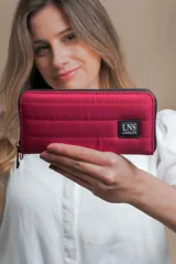 Billetera larga con cierre perimetral, confeccionada en nylon capitoneado color verde petróleo. Cuenta con correa de mano desmontable con logo estampado y parche frontal con marca LNS.