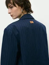 Blazer de corte sastrero en color azul marino con diseño de rayas diplomáticas. Presenta solapas clásicas, cierre frontal con un botón y bolsillos laterales con solapa.
