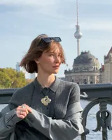 Collar con dije grande de bronce con forma orgánica y textura rugosa, suspendido de un cordón negro. Incluye cordones intercambiables.