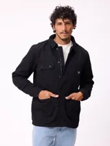Campera de gabardina negra, con cuello camisero, cierre frontal de cremallera y botones a presión. Posee múltiples bolsillos frontales con solapa y puños ajustables con botones.
