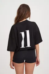 Camiseta negra de manga corta con cuello en V, corte holgado y cordón ajustable en la cintura.