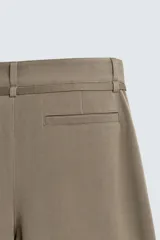 Pantalón de corte balloon fit en color gris, confeccionado en tejido con viscosa. Presenta pliegues frontales, cintura con cinturón integrado a contraste, bolsillos laterales y bolsillos traseros de vivo.