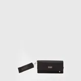 Billetera rectangular de diseño alargado y funcional, color negro, con solapa frontal y logo de la marca en metal plateado. Incluye una correa de mano de tela con el nombre de la marca grabado y cierre de mosquetón.