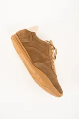 Zapatilla marrón de gamuza con cordones y suela de goma.