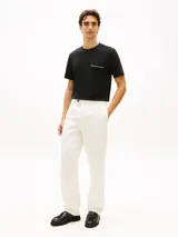 Remera de manga corta color negro, de corte regular fit y cuello redondo. Cuenta con un bolsillo en el pecho adornado con una cinta distintiva de líneas roja, blanca y azul.