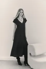 Vestido largo de viscosa jacquard, con escote en V y mangas cortas. Presenta detalle de ojalillos metálicos decorativos en el escote y en los bordes de las mangas, y tablas en las mangas.