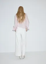 Jeans estilo wide leg de tiro alto en color blanco, con bolsillos de parche delanteros y cierre de cremallera y botón.