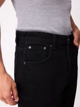 Jean de corte slouchy fit, confeccionado en denim de algodón color azul medio. Presenta diseño de cinco bolsillos, cierre frontal con botón y costuras reforzadas en tono contrastante.