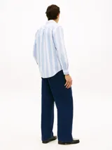 Camisa de corte clásico de puro algodón Oxford, con diseño de rayas verticales en color celeste y blanco. Cuenta con cuello abotonado, bolsillo frontal de parche con un escudo bordado y mangas largas con puños redondeados.