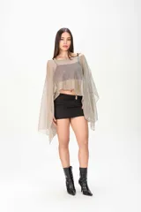 Poncho negro de tejido traslúcido con brillo sutil, mangas amplias y caída asimétrica.