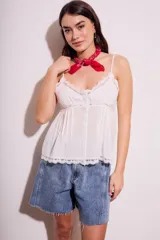 Blusa de algodón color blanco con breteles finos, escote en V con detalles de encaje, cierre frontal con botones y diseño holgado.