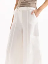 Pantalon wide leg blanco de lino, con tiro alto y bolsillos cargo laterales. Incluye cinturón con hebilla metálica.
