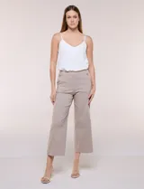 Pantalón crop color beige de corte recto, con cintura ancha, botones decorativos en los laterales y pinzas verticales frontales.
