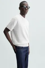 Camiseta negra de punto perlado, corte regular fit, cuello redondo, manga corta y rib en los acabados.