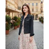 Campera de jean color negro con apliques de perlas en la parte superior frontal. Presenta cuello clásico, cierre frontal con botones metálicos y dos bolsillos en el pecho.